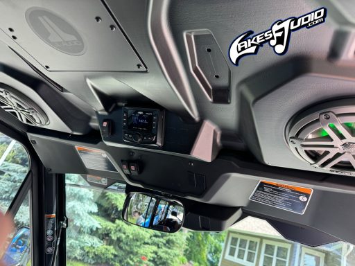 Can-Am Defender Interior view of a boat dashboard with speakers and a digital display.