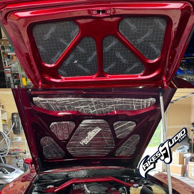 1968 Dodge Charger Red car hood lifted, revealing the engine compartment and interior details.