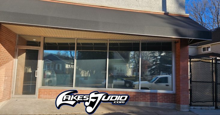 Building Window Tint Clear storefront with large windows and a black awning, featuring a logo at the bottom.
