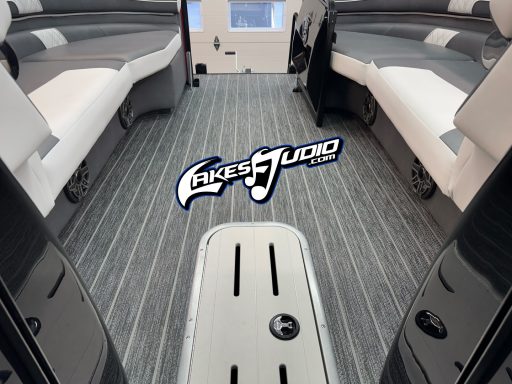 Premier Pontoon Interior of a boat featuring cushioned seating and a patterned floor, with a logo in the center.